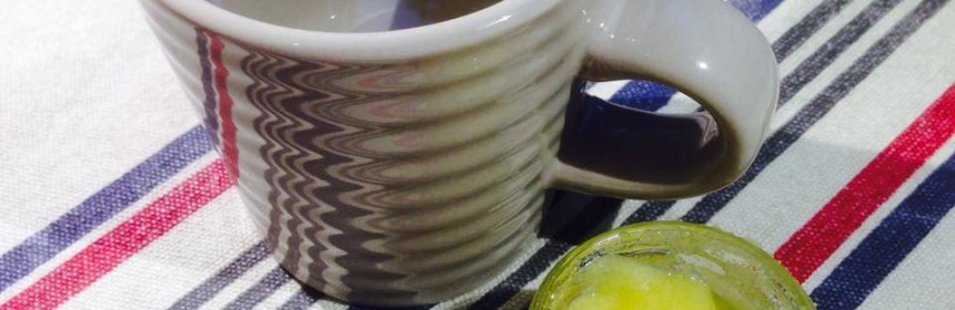 en mugg vatten och en glasskål med ghi