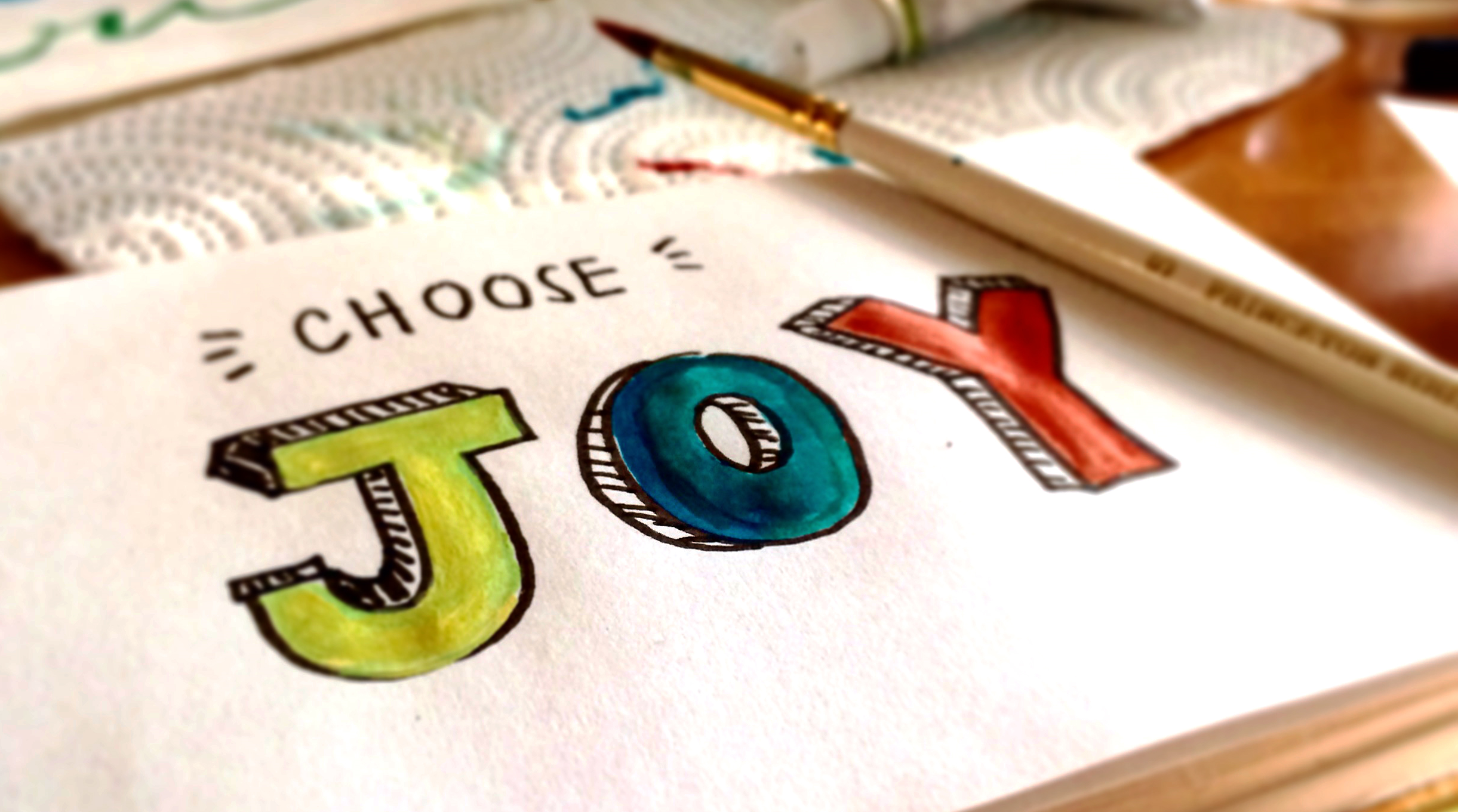 Papper med målad text "Choose Joy"