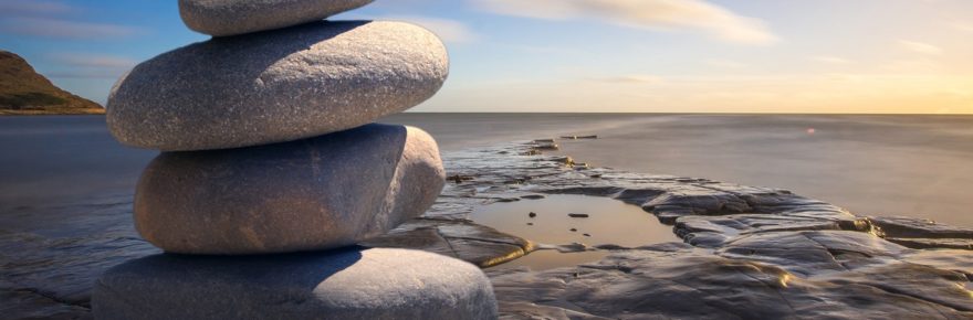 Stenar på hög på en klippa med hav i bakgrunden