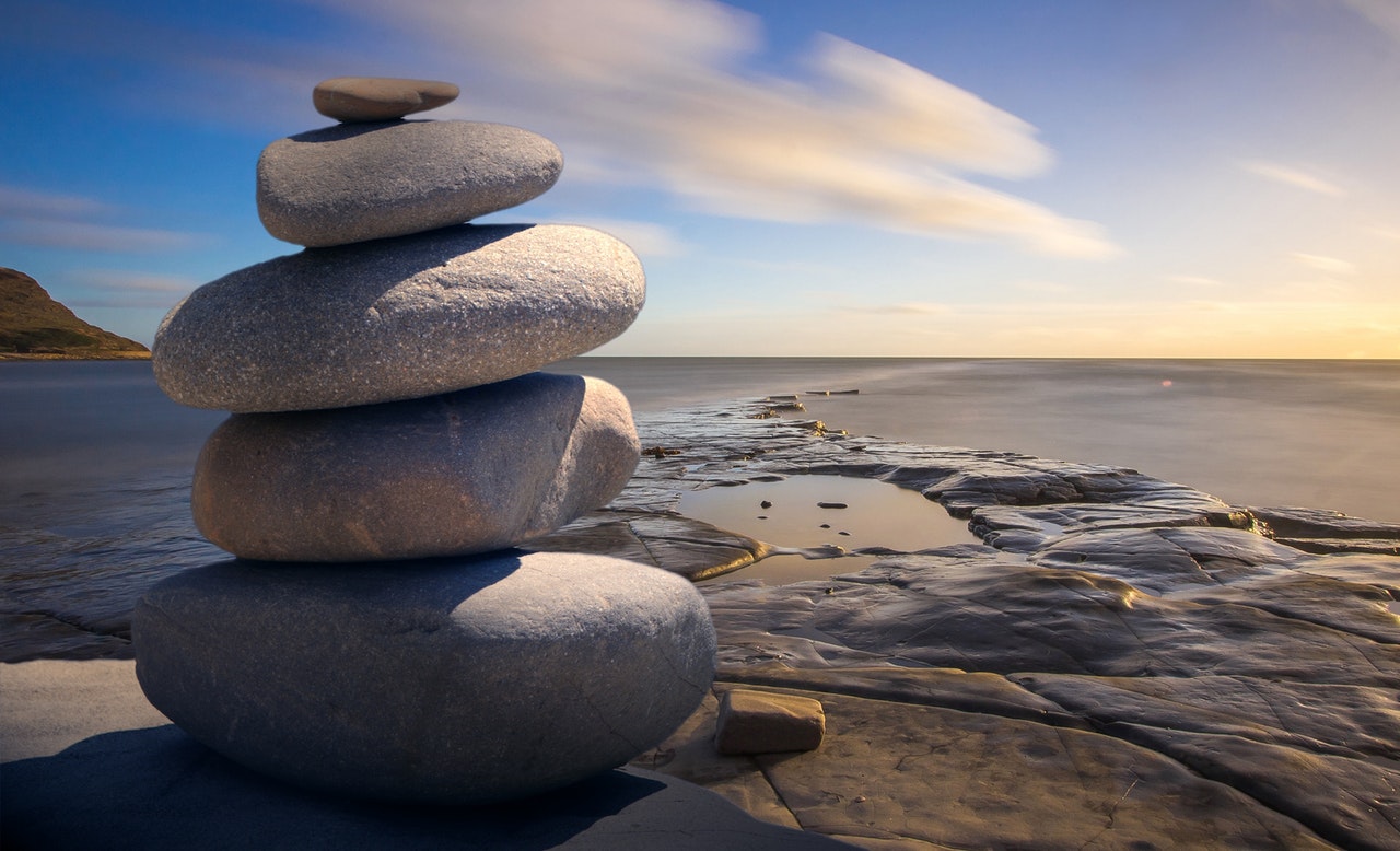 Stenar på hög på en klippa med hav i bakgrunden